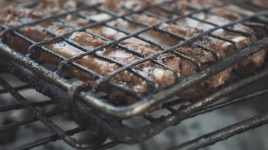 Açık havada ızgarada domuz pirzolası çeviriyorum. Kimliği belirsiz kişi ızgarada kızarmış et pişiriyor. Yemek, mangal, aşçılık, parti.