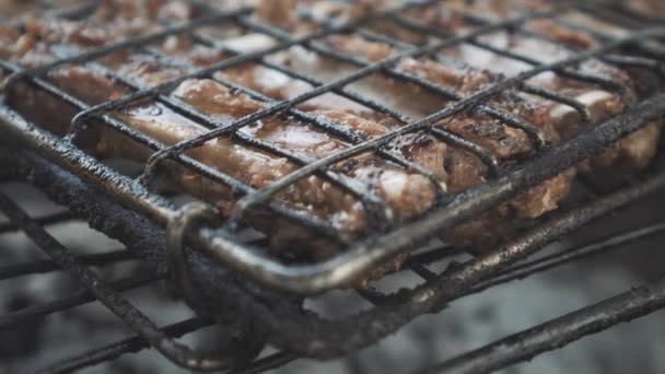 Girando di costolette di maiale sulla griglia barbecue all'aperto. Persona sconosciuta che cucina gustosa carne fritta sul barbecue. Cibo, barbecue, culinario, festa . — Video Stock