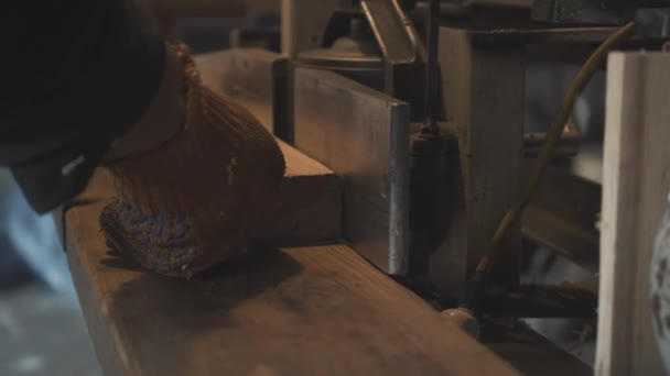 Mannelijke handen snijden of polijsten hout met behulp van apparatuur. Onherkenbaar zelfverzekerde man in het werken handschoenen productie houten item met houtbewerkingsmachine. Timmerwerk, hobby, beroep, levensstijl. — Stockvideo