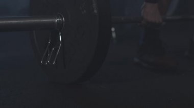 Kafkas sporcusu tarafından sisli spor salonunda kaldırılan halterin yakın çekimi. Tanımlanamayan adam sisli fitness kulübünde çalışıyor. Sağlık, vücut geliştirme, spor, halter, yaşam tarzı.