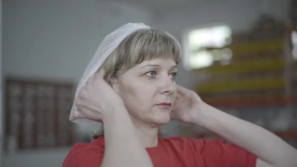 보호 모자를 쓰고 공장을 떠나는 백인 여성의 초상화. 생산 라인에 있는 전문 여성 공장 노동자의 근접 사진. 산업, 직업, 생활 방식, 제조업. — 비디오