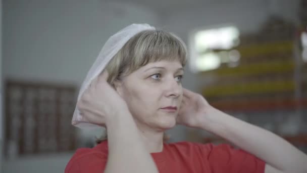 Retrato de mulher caucasiana colocando chapéu protetor na fábrica e partida. Close-up de operária especializada na linha de produção. Indústria, ocupação, estilo de vida, manufatura . — Vídeo de Stock