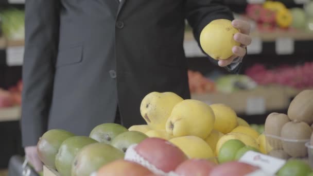 Oigenkännlig ung kaukasisk man väljer gula päron i mataffären. Man vegan väljer frukt från hyllan i detaljhandeln. Livsstil, hälsosam mat, vitaminmat. S-log 2. — Stockvideo