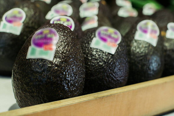 Close-up of delicious blue avocado on shelf in grocery. Vitamins, fresh organic food, healthy eating. Stock Photo