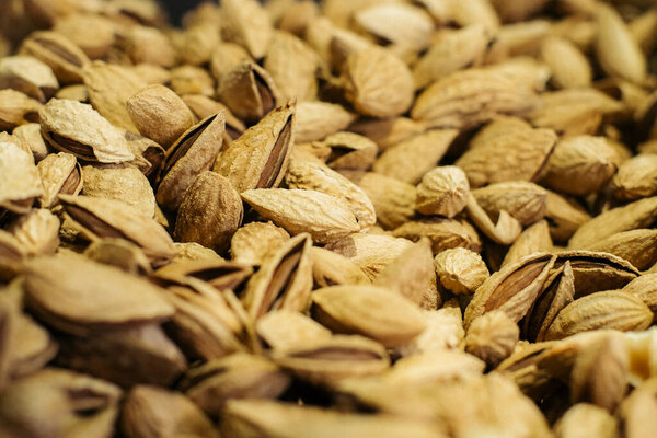 Brown pistachios lying on the shelf in grocery store. Bunch of fresh nuts for sale in supermarket. Healthy eating, vegetarianism, vegan food, culinary. Stock Image