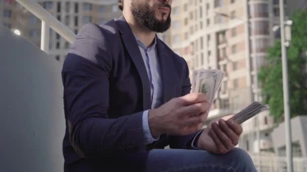 Un exitoso empresario irreconocible de Oriente Medio contando dinero al aire libre. Retrato del rico rico calculando ingresos en la calle urbana. Estilo de vida, éxito, buena inversión . — Vídeos de Stock