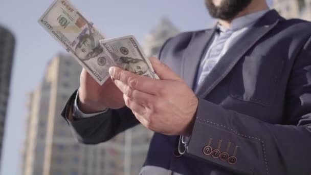 Unrecognizable bearded man in suit scattering money and laughing. Successful happy Middle Eastern businessman enjoying wealth standing outdoors on sunny day. Joy, lifestyle, business, richness. — Stock Video