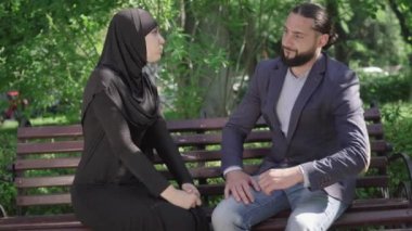 Sunny Park 'ta bankta oturmuş tartışan üzgün bir Orta Doğulu çiftin portresi. Yakışıklı bir adam ve tesettürlü genç bir kadın açık havada kavga ediyorlar. Evlilik sorunları, ilişki sorunları.