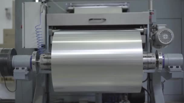 Rollo grande de lámina de aluminio que rueda en la maquinaria industrial. Equipos que trabajan en la fábrica procesando materia prima. Negocios, fabricación, producción. Cámara avanza . — Vídeo de stock