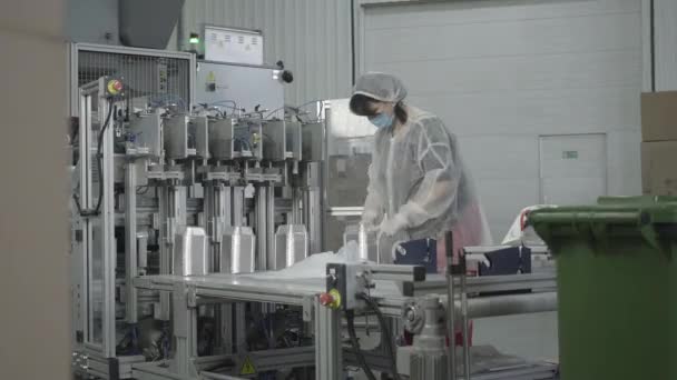 Retrato de mujer caucásica concentrada tomando productos terminados de la máquina de clasificación automatizada y embalando contenedores de platos de alimentos. Proceso de fabricación en fábrica. Industria, fabricación, negocio . — Vídeo de stock