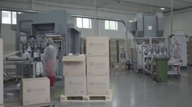 Yüz maskeleriyle çalışan işçilerle endüstriyel üretim alanının geniş açılı görüntüsü. Covid-19 salgını sırasında fabrika yemek kapları üretiyor. Taşıyıcı, endüstri, üretim, koronavirüs.