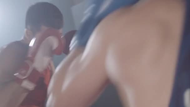 Серйозні кавказькі боксери борються на боксерському рингу. Молоді впевнені спортсмени тренуються в туманному темному спортзалі з заднім світлом. Спарювання, боротьба, бойові мистецтва. Жива камера. Фільм 4k ProRes HQ. — стокове відео