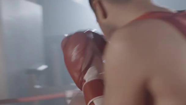 Pugili sportivi attivi che combattono sul ring di boxe. Due forti sportivi caucasici fiduciosi combattono nella foschia con retroilluminazione sullo sfondo. Videocamera in diretta. Cinema 4k ProRes HQ. — Video Stock