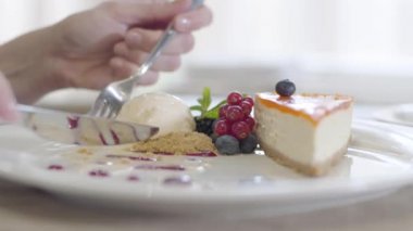 Tabaktaki lezzetli tatlıyı yakın plan çek. Beyaz bir kadın, çatalla dondurma yiyor. Restoranda ya da kafede yemek yiyen tanınmayan genç bir kadın. Yemek, aşçılık, tatlı, yaşam tarzı, eğlence..