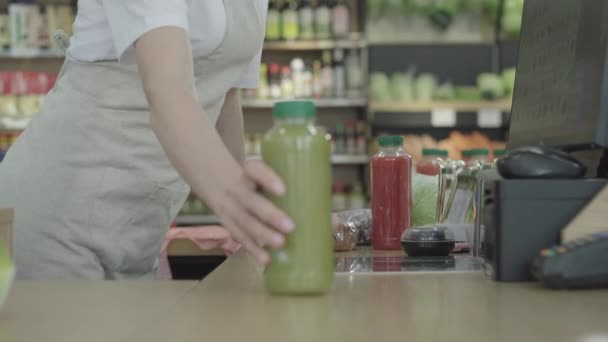 Caixa feminina irreconhecível a verificar mercadorias na mercearia. Vista lateral da jovem empregada que trabalha na loja de alimentos. Consumismo, comércio, venda, estilo de vida . — Vídeo de Stock