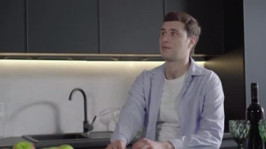 Genç, gülümseyen, beyaz bir adam evde erkek arkadaşını selamlıyor ve sarılıyor. Neşeli eşcinsel çiftin buluşması ve konuşması portresi. Neşe, lgbt yaşam tarzı, aşk, bağ, mutluluk.