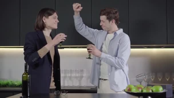 Pasangan gay ceria menari dengan gelas anggur di dapur. Sisi tampilan tengah tersenyum bahagia pria Kaukasia menikmati ulang tahun. Lgbt kebanggaan, pernikahan seks yang sama, gaya hidup. — Stok Video