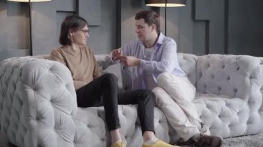 Kendine güveni tam mutlu bir adam erkek ortağın parmağına yüzük takıyor. Kafkasyalı homoseksüel çiftin ilişkileri yasallaştırma portresi. Aynı cinsiyet evlilik kavramı.