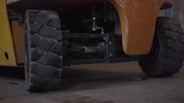 Großaufnahme der sich drehenden Radlader im Lager der Fabrik. Industrieanlagen, die in Lagerräumen arbeiten. Transport, Logistik. — Stockvideo