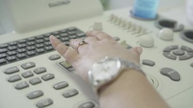 Tıbbi ekipmanlardaki kadın el basma düğmesine yakın çekim. Tanımlanamayan Kafkasyalı doktor hastanede muayene yapıyor. Yaşam tarzı, sağlık hizmetleri, ilaçlar.