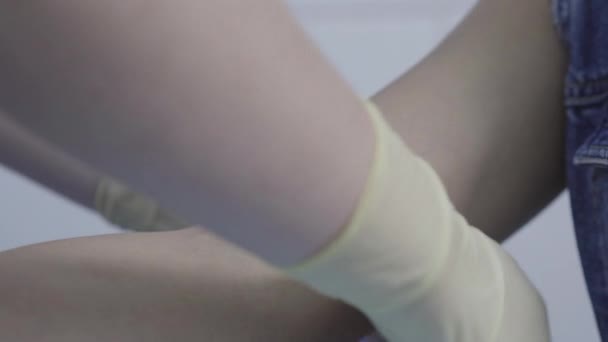 Primo piano estremo di giovane mano femminile con benda applicata in ospedale. Infermiera donna non riconoscibile con i guanti che prepara il paziente agli esami del sangue. Concetto di assistenza sanitaria, sviluppo del vaccino Covid-19. — Video Stock