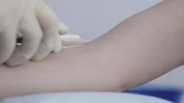 Extrémní detailní záběr rukou ošetřovatelky v rukavicích, které dávají ubrousek na ženskou ruku a vyjímají stříkačku se vzorkem krve. Nerozpoznatelný bělošský lékař provádějící lékařské vyšetření pro diagnostiku. — Stock video