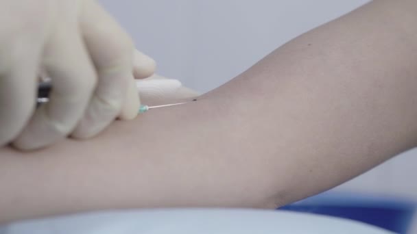 Primer plano extremo de las manos de la enfermera con guantes que ponen servilleta en la mano femenina y sacan la jeringa con muestra de sangre. Médico caucásico irreconocible haciendo examen médico para el diagnóstico . — Vídeos de Stock