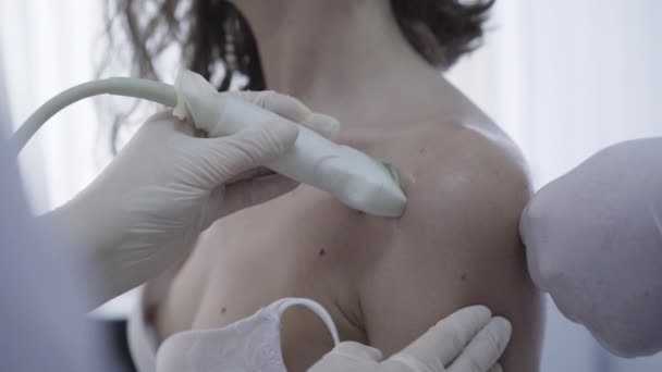 Onherkenbare arts die zieke schouder van jonge blanke vrouw behandelt. Verpleegster en arts doen echografie en het maken van injectie in vrouwelijke patiënten arm. Reumatologie, geneeskunde, gezondheidszorg. — Stockvideo