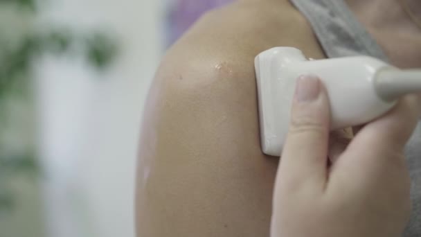 Primer plano de la mano de las médicas con equipo de ultrasonido. Médico caucásico irreconocible o enfermera examinando la articulación del hombro del paciente en el hospital. Medicina, tratamiento . — Vídeos de Stock