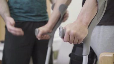 Koltuk değneği tutan erkeklerin yakın çekimleri hastane koğuşunda yürümeye başlıyor. Tanımlanamayan hemşire ya da gönüllü olarak yaralı gazi ya da sporcuya rehabilitasyonda yardım ediyor. İlaç, sağlık, travma.