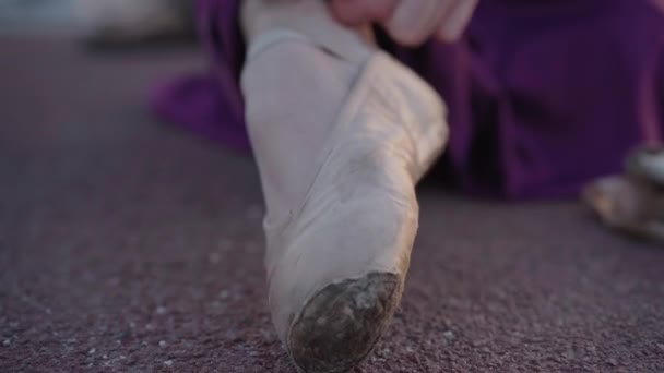 Extreme close-up of female foot in pointes. Camera moves along leg of Caucasian ballerina tying up pointe shoes. Elegance, choreography, dancing. — Stock Video