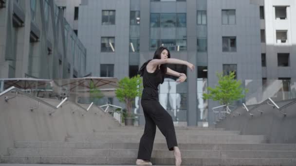 Amplio plano de bailarina de ballet clásica profesional actuando en el fondo de un moderno edificio de oficinas. Retrato de elegante bailarina caucásica delgada bailando en la ciudad urbana . — Vídeos de Stock