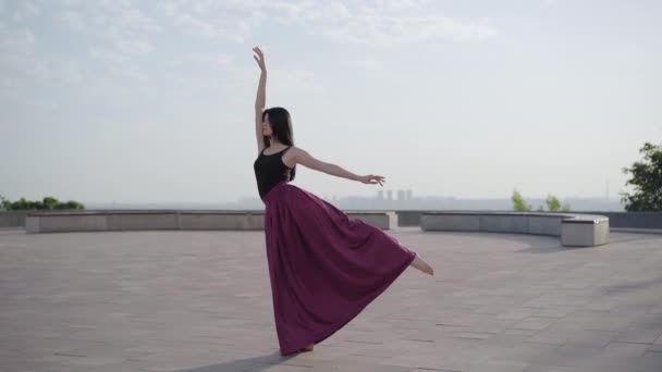 Encantadora bailarina profesional de pie en posición de ballet clásico al aire libre. Amplio retrato de la atractiva joven caucásica bailando en el soleado día de verano en la plaza urbana . — Vídeos de Stock