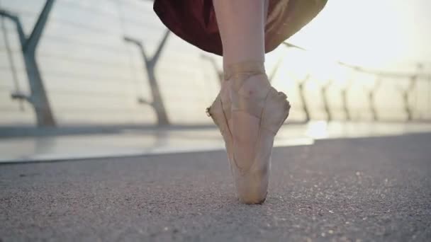 Närbild av kvinnliga balettdansares fötter stående på tå. Oigenkännlig kaukasisk ballerina dans vid soluppgång eller solnedgång utomhus. begreppet koreografi, elegans, skönhet. — Stockvideo