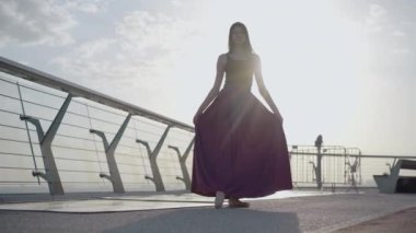 Kameraya parmak uçlarında yürüyen zarif bir balerin. Açık havada güneş ışığında dans eden kendine güvenen beyaz kadın portresi. Gün doğumunda ya da batımında dans eden kadın balerin..