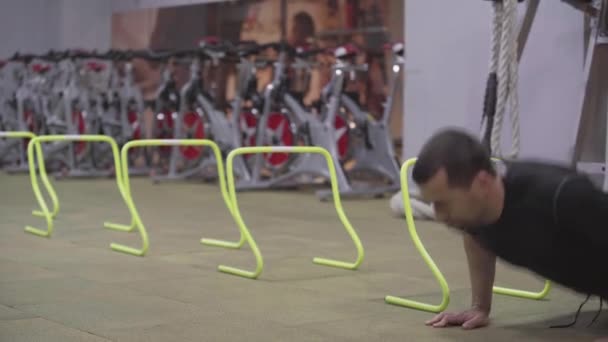 Fuerte deportista caucásico empujando hacia arriba y saltando sobre la barrera. Entrenamiento de atlético hombre caucásico en el gimnasio. Entrenamiento seguro de morena culturista. Deporte, estilo de vida, fuerza . — Vídeos de Stock