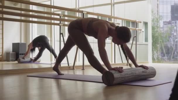 Schlanke, flexible, brünette Frau, die sich auf einer Yogamatte mit Inventar dehnt. Breites Porträt einer selbstbewussten jungen Sportlerin, die im Sportverein trainiert. Kaukasische Mädchen trainieren im Fitnessstudio. — Stockvideo