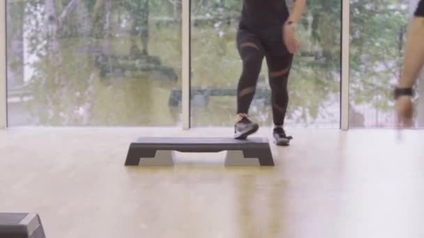 Cámara en vivo, mujer positiva mostrando movimiento en el gimnasio. Retrato de una instructora caucásica entrenando a personas en un club deportivo. Joven deportista activa en el lugar de trabajo . — Vídeo de stock