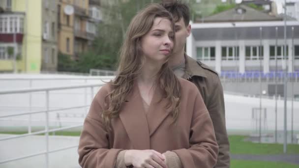 En medio de un amoroso hombre romántico abrazando a su novia al aire libre. Retrato de feliz joven pareja caucásica de pie en la calle urbana de la ciudad. Citas, amor, romance, unidad . — Vídeos de Stock