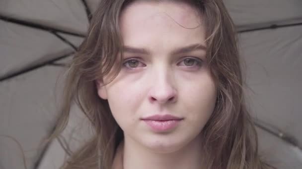 Close-up face of gorgeous sad woman crying outdoors on rainy windy day. Portrait of beautiful brunette Caucasian girl with hazel eyes looking at camera. Negative emotions, problems, lifestyle, beauty. — Stock Video