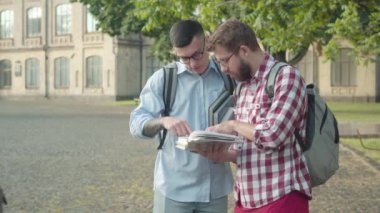 Kolej bahçesinde çalışan zeki çocuklar, buradan geçen kadın grup arkadaşları hakkında tartışıyorlardı. Üniversitede güzel kızları görmezden gelen beyaz erkek ineklerin portresi. Yaşam tarzı kavramı.