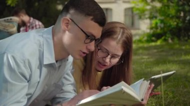 Gözlüklü, yakışıklı, zeki çocuğun, çekici kızıl saçlı kızla kitabı tartışmasının yan görüntüsü. Kampüste güneşli bir günde dışarı çıkan beyaz öğrencilerin portresi. Aşk, aşk.