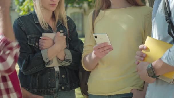 Groep onherkenbare groepgenoten die online testresultaten controleren in smartphone. Een mannelijke student die een overwinningsgebaar maakt als een ander hoofd vasthoudend met de hand. Teamwork, vriendschap, onderwijs. — Stockvideo