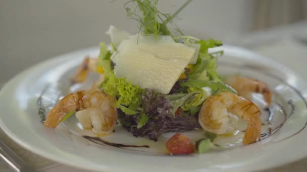 Prato branco com camarões cozidos e legumes em pé sobre a mesa no restaurante. Close-up de deliciosos frutos do mar saudáveis no café ao ar livre no resort de luxo. Conceito de alimentação saudável, turismo . — Vídeo de Stock