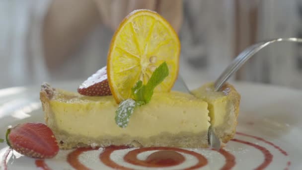 Close-up de mulher irreconhecível deliciosa torta com faca e garfo. Menina caucasiana tomando pedaço de bolo para comer no café ou restaurante . — Vídeo de Stock