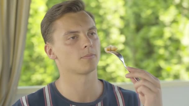 Primer plano de joven morena hombre caucásico con ojos marrones degustación de deliciosos camarones horneados en la cafetería al aire libre. Retrato del cliente rico satisfecho degustando mariscos en un lujoso restaurante en un día soleado . — Vídeos de Stock