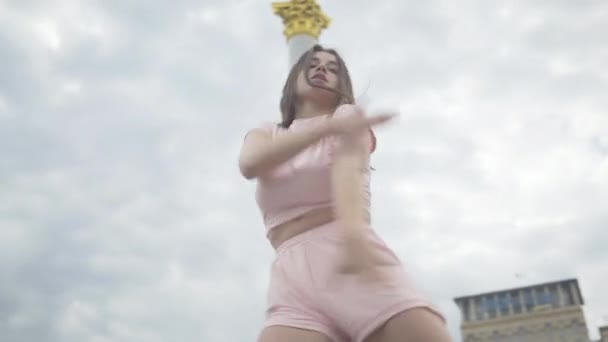 Портрет молодої чуттєвої кавказької жінки, що танцює на міській площі. Красуня Брюнет виступає на міській вулиці європейського міста. Професійна танцівниця. — стокове відео