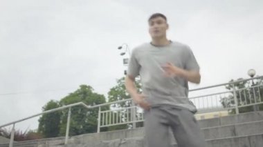 Kamera aktif genç adamdan uzaklaşıyor şehir merdivenlerinde dans eden neşeli gençlerden oluşan bir gruba taşınıyor. Açık havada özgürlüğün tadını çıkaran profesyonel beyaz dansçıların portresi..