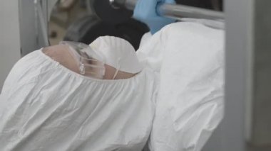 Spor salonundaki koruyucu gözlüklü ve halteri kaldıran sporcu kadının yakın görüntüsü. Covid-19 salgınında genç beyaz kadın eğitiminin portresi..
