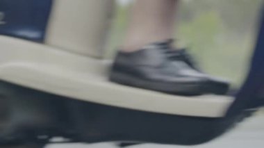 Canlı kamera, ıslak asfalt boyunca skuterin altından geçiyor. Yağmurlu bir günde yolda motosiklet sürerken tanınmaz haldeydi. Hız ve yarış konsepti.